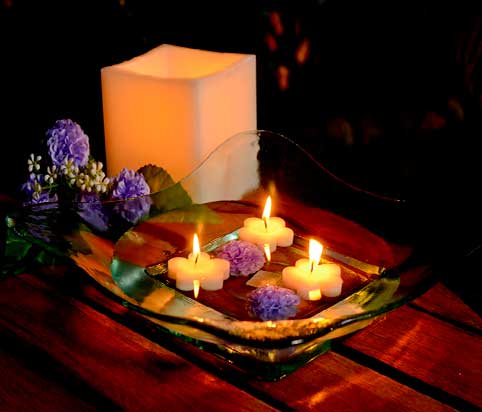 velas-flotantes-de-forma-de-flores-en-centro-de-mesa-de-cristal-con-peonias-azules