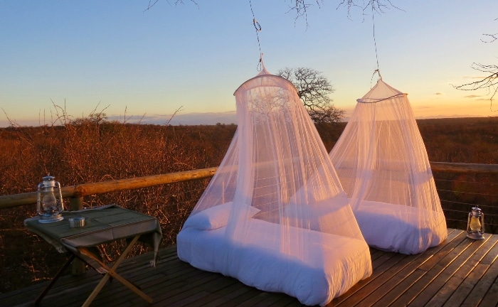 camas blancas con mosquitera al aire libre