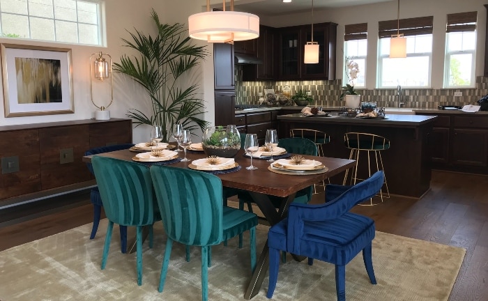 comedor elegante en cocina, con sills en raso azul y verde, lámpara sobre mesa
