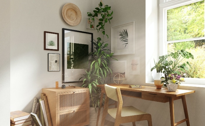 escritorio de madera con varias plantas, ciadros y detalles en pared