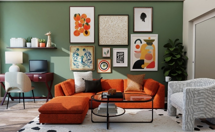 sofá naranja con muchos cojines, pared verde, sillón blanco y diferentes cuadros