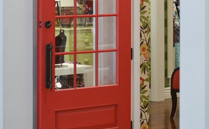 detalle de puerta de cristal y lacada en rojo, con manilla metálica en negro