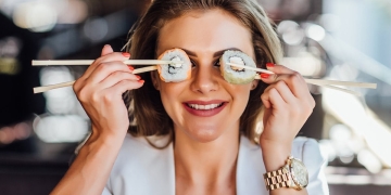 mujer feliz come sushi