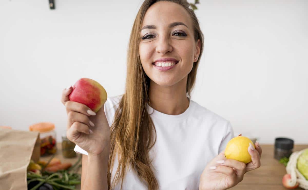 mujer feliz comiendo frutas para adelgazar