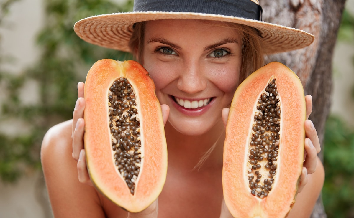 mujer feliz comiendo semillas papaya