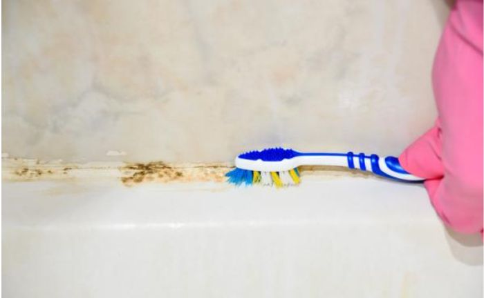 Limpieza bañera cepillo dientes viejo